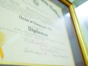 Ein gerahmtes Diplom mit goldenem Siegel liegt auf einer hellen Oberfläche und steht für Bildungserfolg und Zertifizierung.