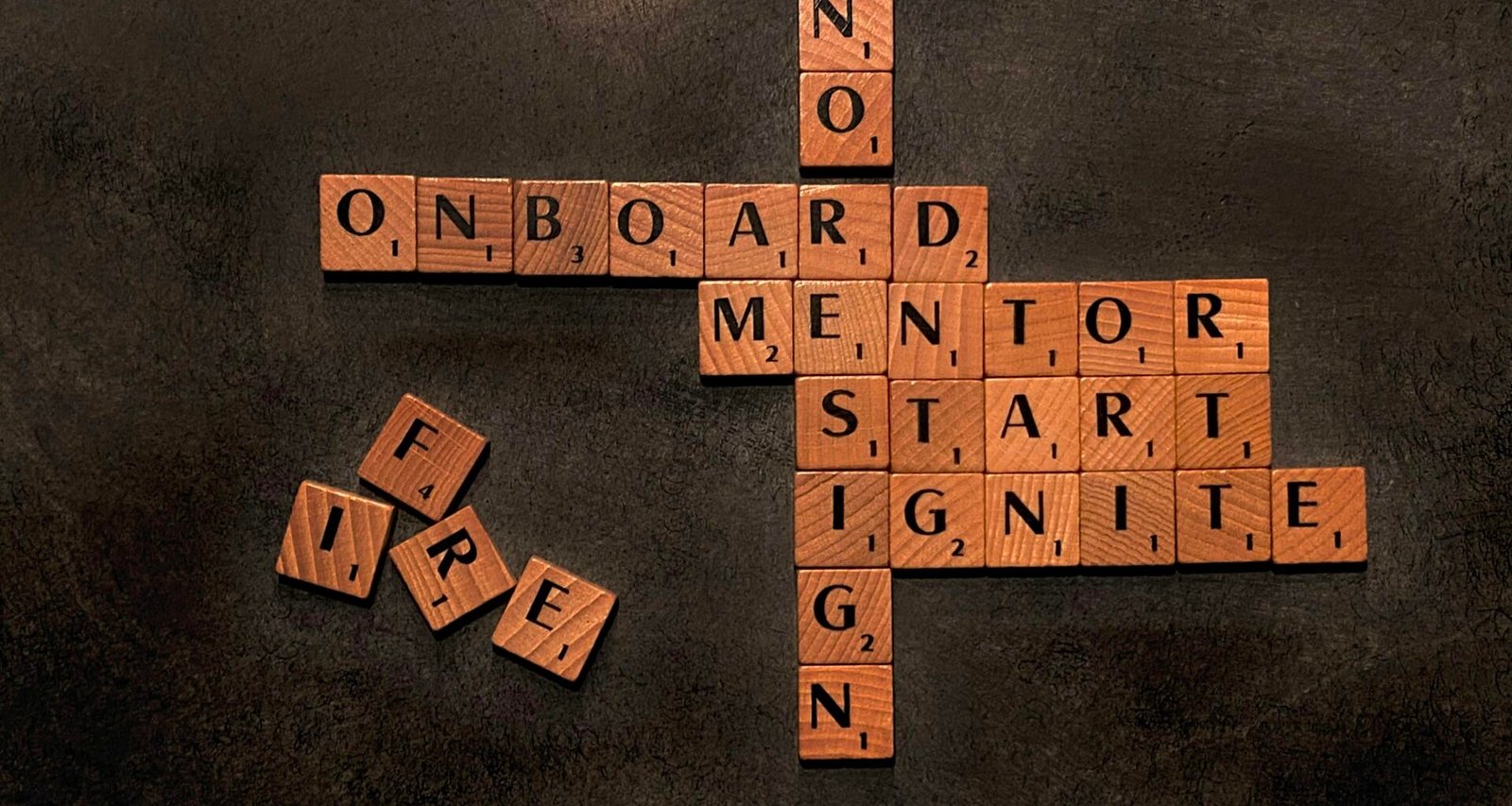 Auf einem Scrabble-Brett liegen die Wörter Mentor, Start und Nein aus Buchstabensteinen nebeneinander.