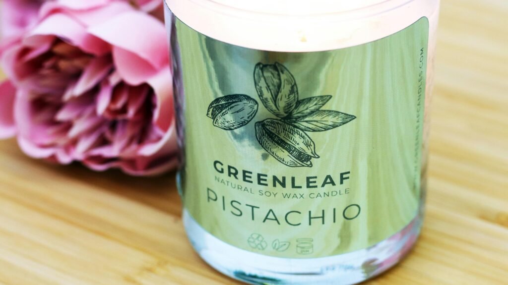 Ein transparenter Glasbehälter mit einem grünen Plastikdeckel steht auf einer neutralen Oberfläche und ist leer.