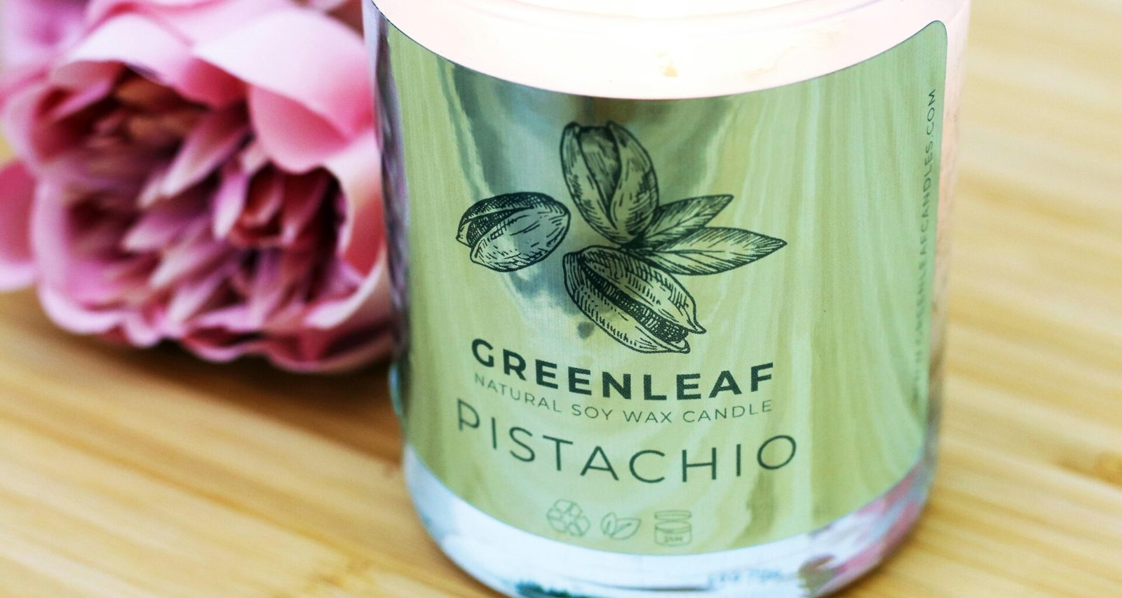 Ein transparenter Glasbehälter mit einem grünen Plastikdeckel steht auf einer neutralen Oberfläche und ist leer.