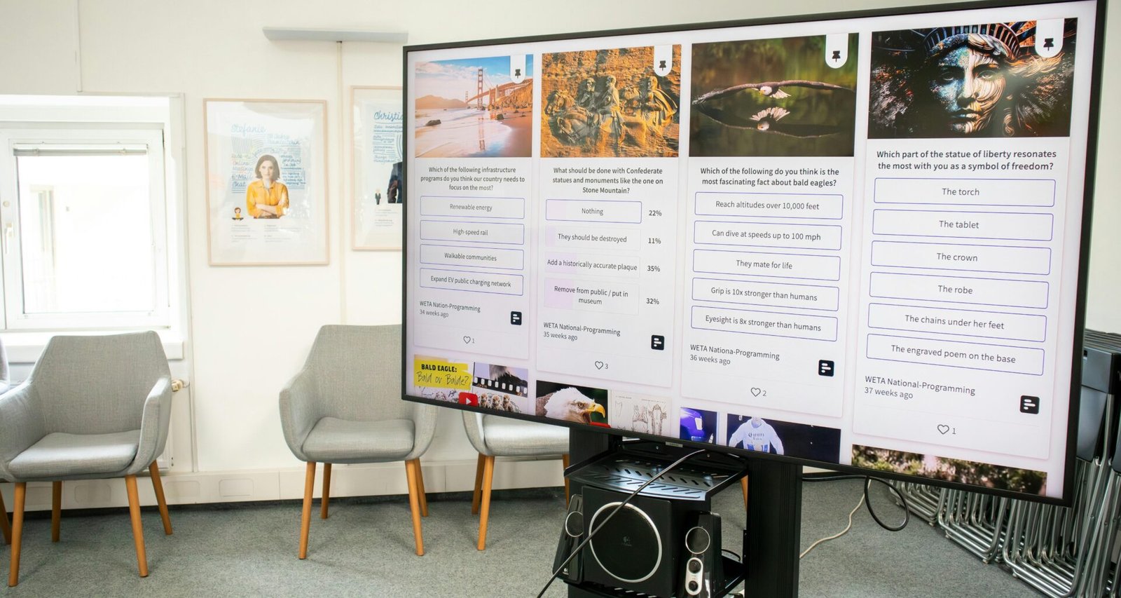 Großer Bildschirm an der Wand in einem modern eingerichteten Raum mit mehreren Stuhlreihen davor.