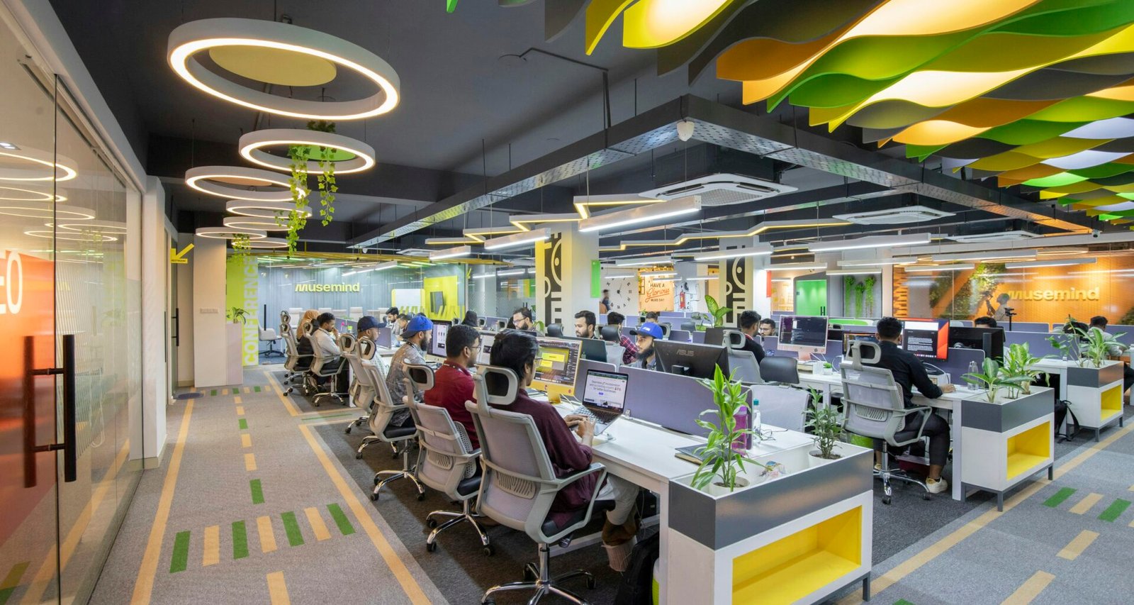 Großzügiges offen gestaltetes Büro mit vielen Schreibtischen und Stühlen, eingerichtete Arbeitsplätze in moderner Arbeitsumgebung