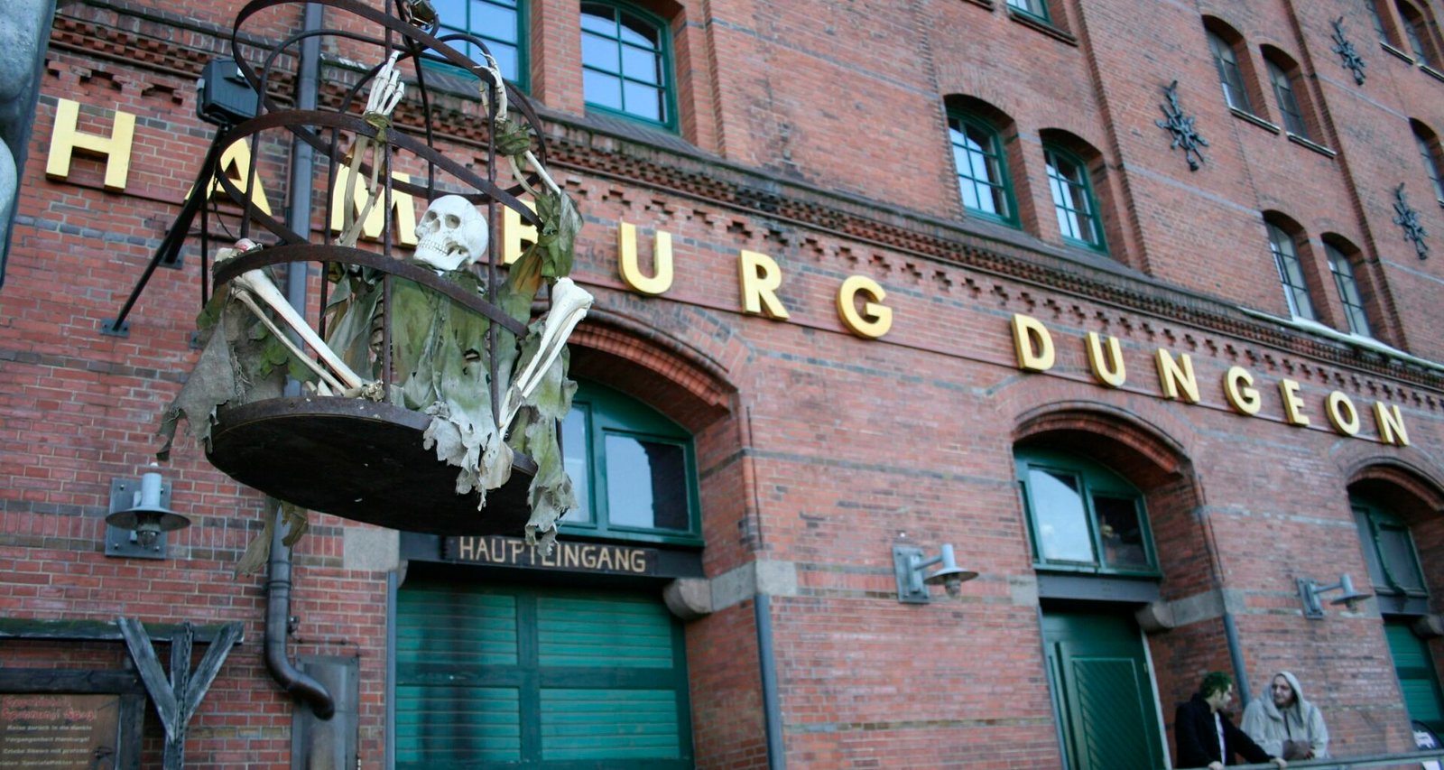Großes Backsteingebäude mit einem sichtbaren Schild an der Vorderseite, aufgenommen in urbaner Umgebung