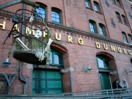 Großes Backsteingebäude mit einem sichtbaren Schild an der Vorderseite, aufgenommen in urbaner Umgebung