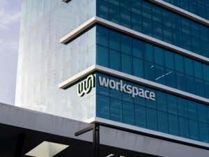 Großes, modernes Bürogebäude aus Glas mit dem Wort Workspace auf der Fassade, Beispiel für zeitgemäße Architektur.