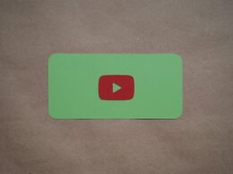 Grünes Rechteck mit rotem Play-Button als Symbol für digitale Videoinhalte auf weißem Hintergrund