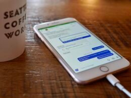 Ein Smartphone liegt auf einem Holztisch, geeignet als Symbolbild für mobile Technologien und Online-Marketing.