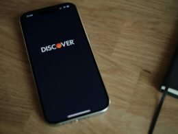 Ein Smartphone liegt auf einem hellen Holztisch und steht exemplarisch für mobile Technologien im täglichen Leben.