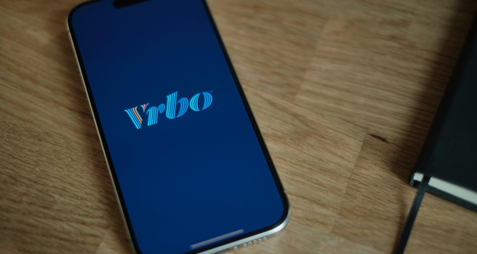 Ein modernes Smartphone liegt auf einer Holzoberfläche, perfekt für Artikel über mobile Technologien und digitale Geräte.