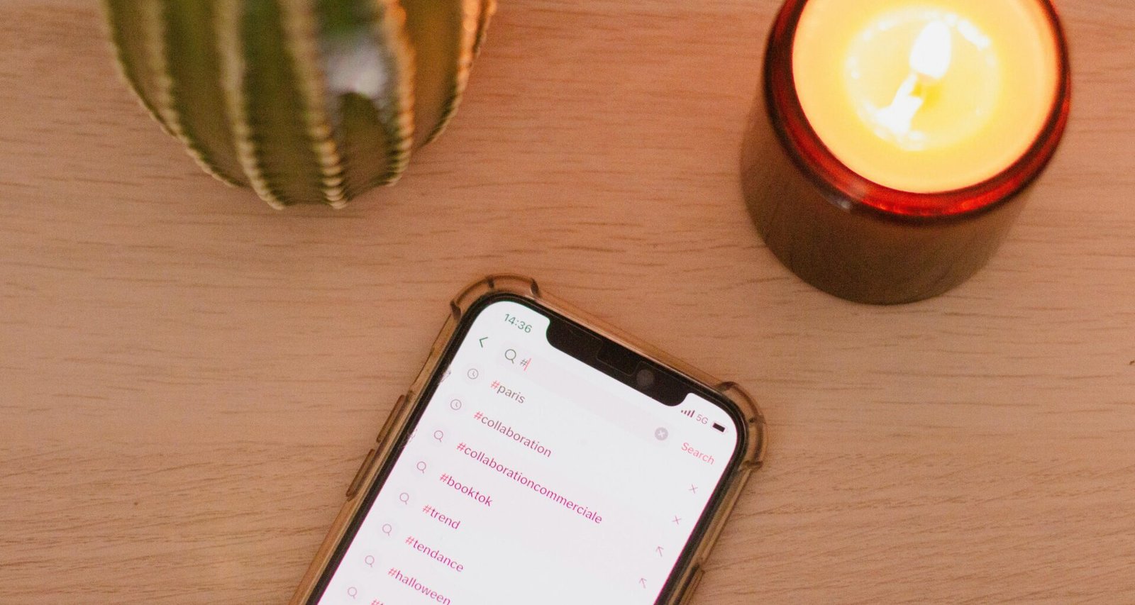 Ein Mobiltelefon liegt mittig auf einem hellen Holztisch, ideal für Themen zu Digitalisierung und mobilem Arbeiten.