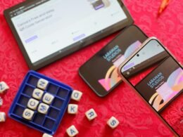 Ein aktuelles Smartphone liegt auf einer ebenmäßigen, roten Tischoberfläche – moderner Technikalltag dargestellt