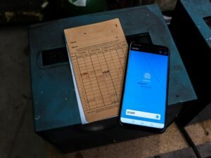 Ein Mobiltelefon liegt auf einem Tisch neben einem Blatt Papier – Symbol für digitales und analoges Arbeiten im Alltag