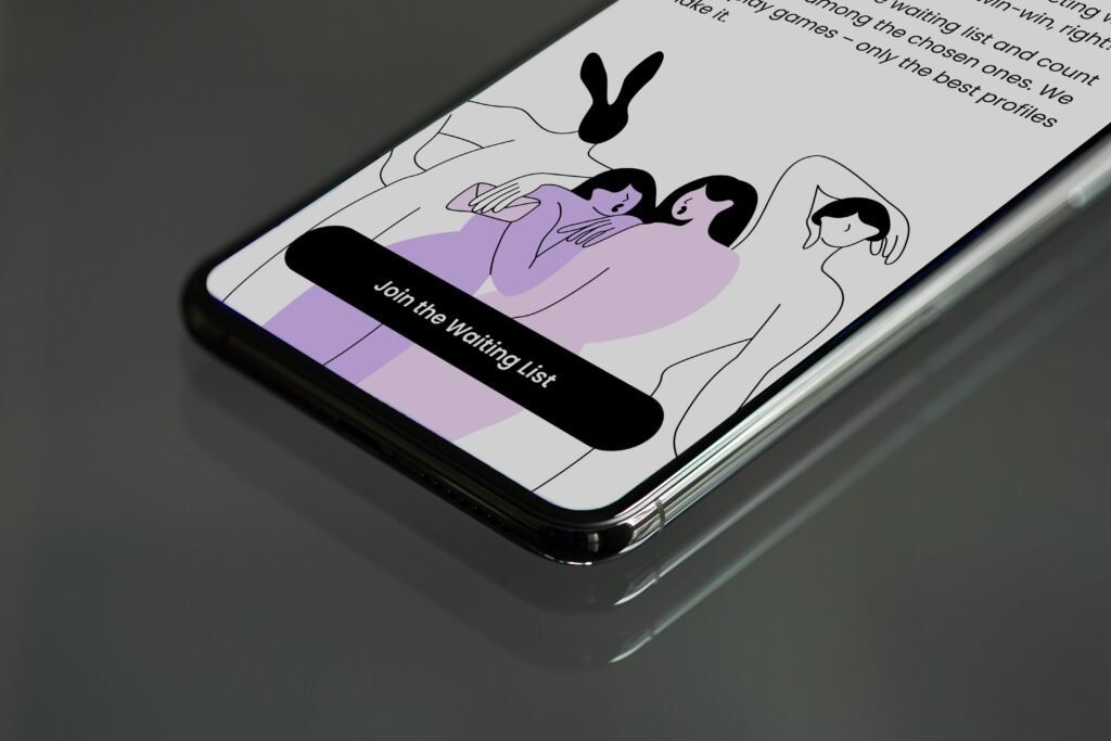 Ein Smartphone zeigt auf seinem Display ein Bild von zwei Personen, aufgenommen aus der Nähe auf neutralem Hintergrund.