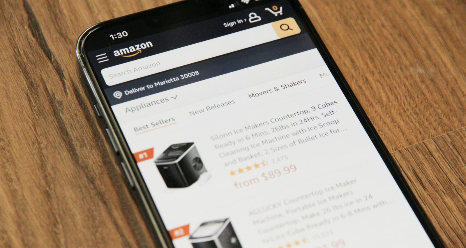Ein Smartphone liegt flach auf einem hellen Holztisch, bereit zur Nutzung – modernes Design und schlichte Umgebung.