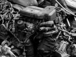 Mehrere gebrauchte Automotoren und Metallteile übereinander gestapelt auf einem Schrottplatz, Ansicht von oben