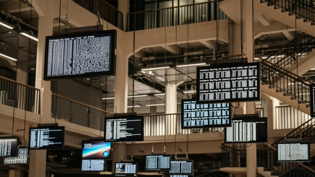 Mehrere Fernseher hängen von der Decke und zeigen unterschiedliche Inhalte auf ihren Bildschirmen.