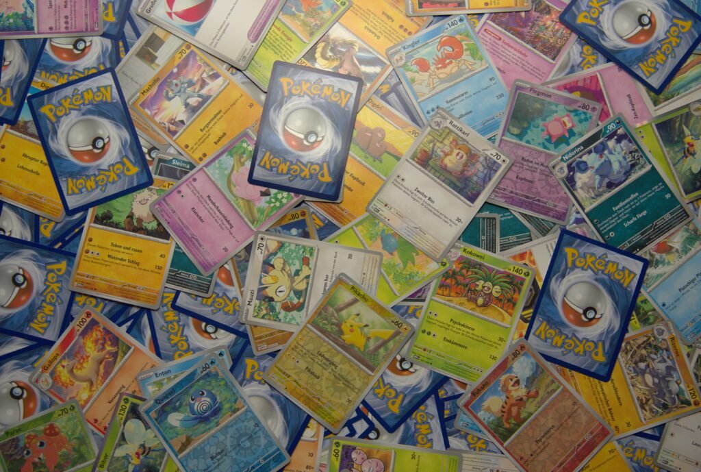 Eine Vielzahl von Pokemon-Karten liegt auf einem Holztisch ausgebreitet – Detailaufnahme für Sammelkarten-Fans.