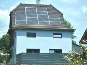 Ein Einfamilienhaus mit einer Solaranlage auf dem Dach zur Gewinnung von Solarstrom an einem sonnigen Tag
