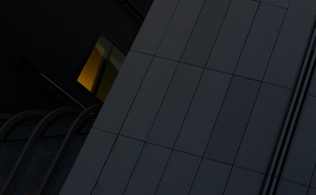 Großes Hochhaus mit integrierter Uhr an der Seite in einer Stadt, fotografiert aus der Froschperspektive