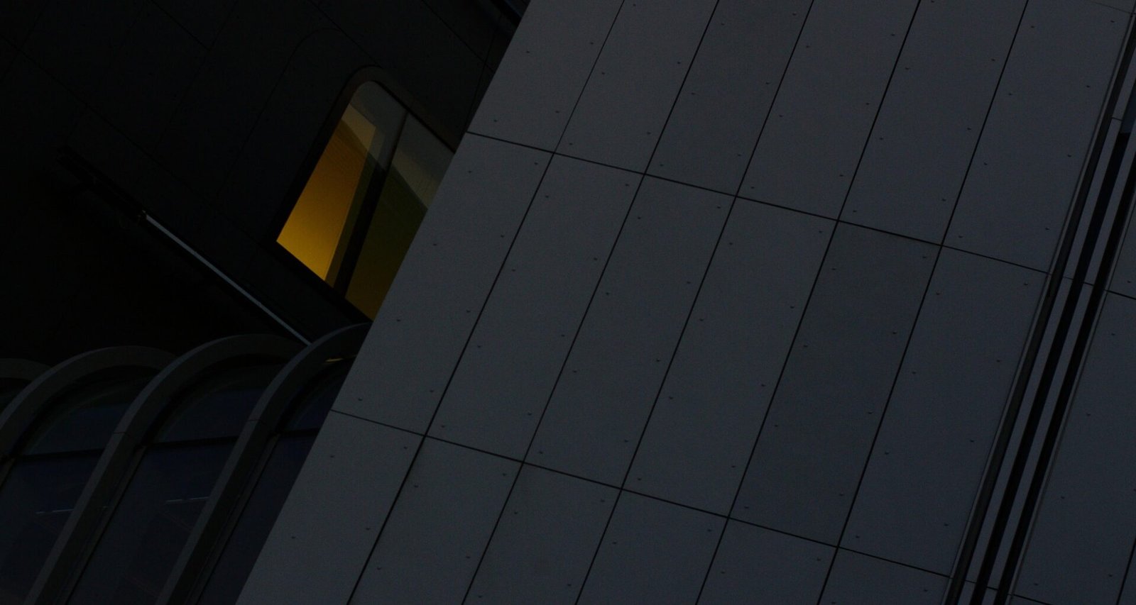 Großes Hochhaus mit integrierter Uhr an der Seite in einer Stadt, fotografiert aus der Froschperspektive