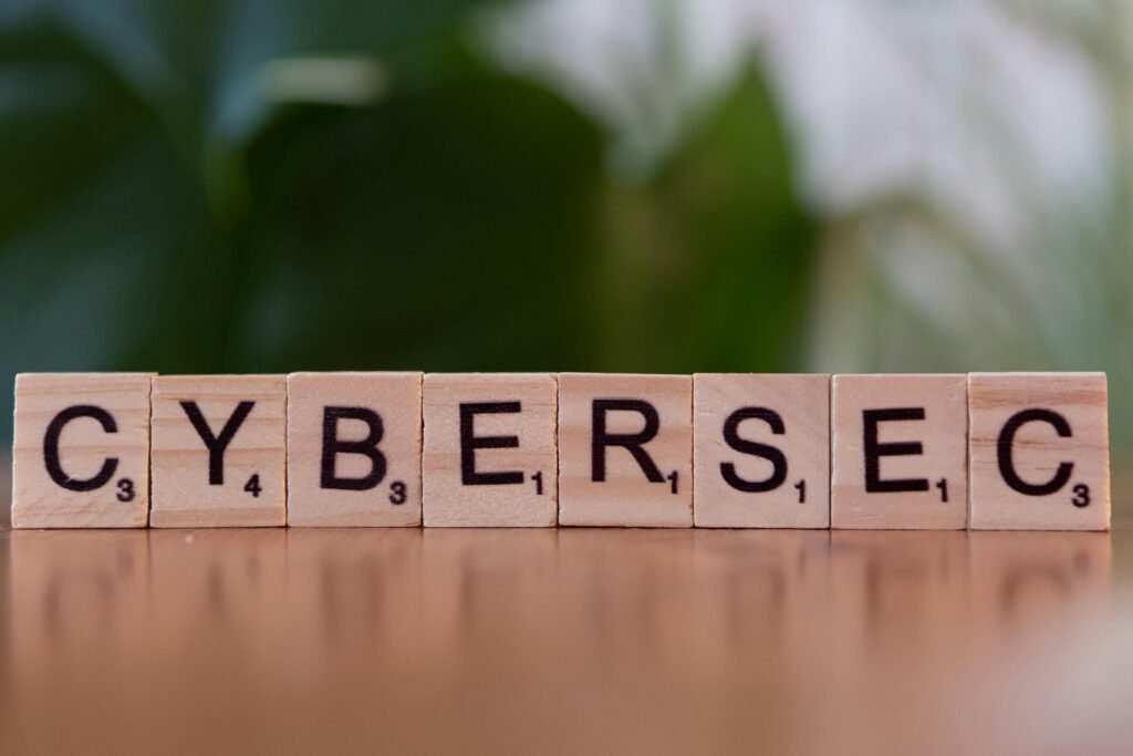 Ein Holzblock mit den Buchstaben 'cybersec' liegt auf einem Tisch und steht symbolisch für Cybersicherheit und IT-Schutz.