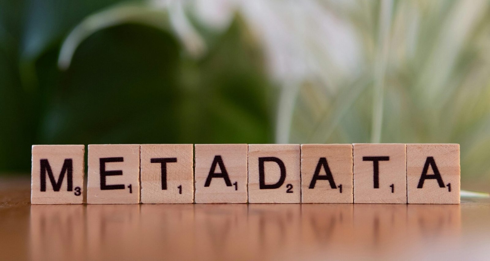 Holzblock mit dem Aufdruck 'metadata' auf einem Tisch als Symbol für Datenorganisation und SEO-Grundlagen.