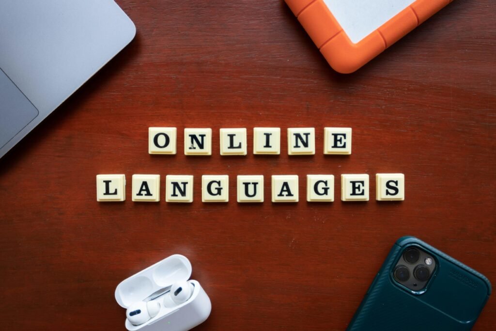 Scrabble-Buchstaben auf einem Holztisch bilden das Wort Online-Sprachen und symbolisieren das Erlernen von Sprachen im Internet