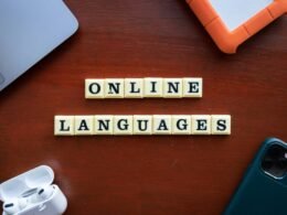 Scrabble-Steine auf einem Holz­tisch bilden den Schriftzug online languages und veranschaulichen Sprachlerntrends.