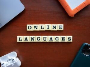 Scrabble-Steine auf einem Holztisch buchstabieren 'Online Languages' und stellen digitale Sprachlernoptionen dar