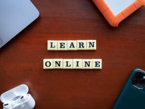 Scrabble-Buchstaben auf einem Holztisch, die 'Learn Online' buchstabieren. Symbol für digitales Lernen und Online-Bildung.