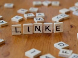 Holztisch mit Scrabble-Steinen, die das Wort Link darstellen, geeignet als Symbolbild für SEO- und Online-Marketing-Inhalte.