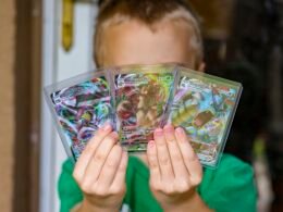 Ein Kind steht im Freien und hält eine transparente Plastiktüte locker in der Hand.