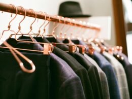 Ein Kleiderständer mit verschiedenen Kleidern und einem Hut auf hellem Hintergrund, abgebildet für einen Artikel über Interior Trends.