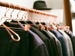 Ein Kleiderständer mit verschiedenen Kleidern und einem Hut auf hellem Hintergrund, abgebildet für einen Artikel über Interior Trends.