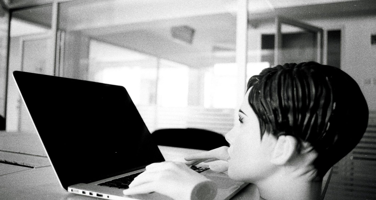 Ein junger Junge sitzt in einem hellen Raum vor einem Laptop und blickt konzentriert auf den Bildschirm