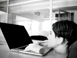 Ein junger Junge sitzt in einem hellen Raum vor einem Laptop und blickt konzentriert auf den Bildschirm