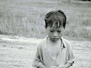 Ein junger Junge steht auf einem offenen Feld und hält ein Frisbee in der Hand