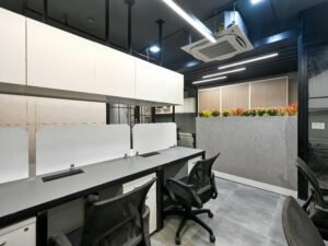 Ein heller Konferenzraum mit mittig platziertem Tisch und umliegenden Stühlen, geeignet für Meetings und Teamarbeit