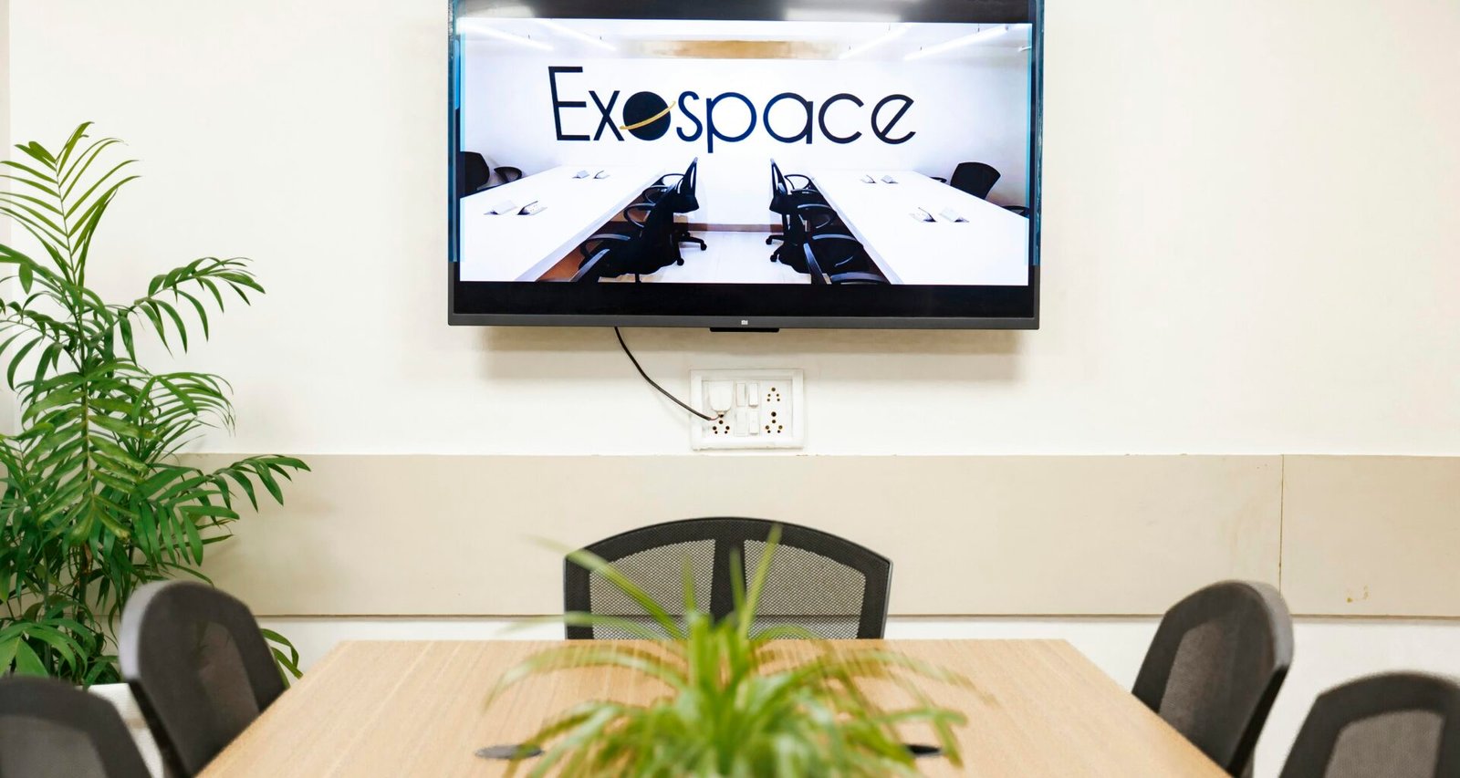 Ein moderner Konferenzraum mit einem großen TV-Bildschirm an der Wand, geeignet für Meetings und Präsentationen.