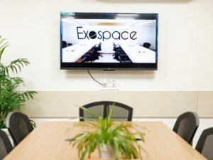 Ein moderner Konferenzraum mit einem großen TV-Bildschirm an der Wand, geeignet für Meetings und Präsentationen.