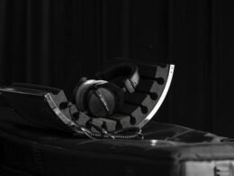 Ein Paar Kopfhörer liegt auf einem Koffer – Symbol für Technik und mobiles Reisen