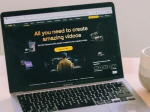 Ein Laptop steht auf einem weißen Tisch, umgeben von minimalistischem Arbeitsplatz-Zubehör in einem modernen Raum.