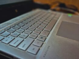 Auf einem Holzschreibtisch steht ein geöffneter Laptop, ideal für Arbeit im Bereich Technologie und Online-Marketing.