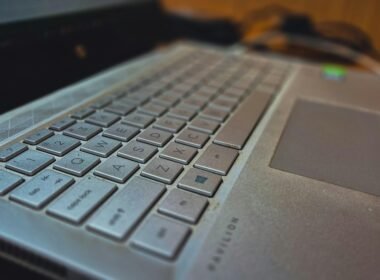 Auf einem Holzschreibtisch steht ein geöffneter Laptop, ideal für Arbeit im Bereich Technologie und Online-Marketing.