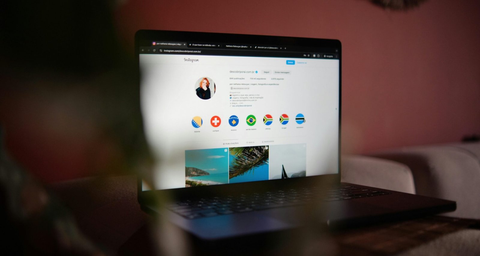 Ein Laptop steht auf einem hölzernen Tisch, fotografiert aus der Seitenperspektive in einem hellen Raum.