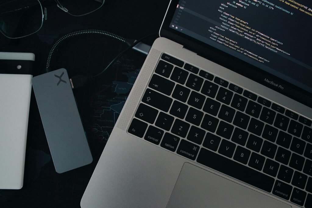 Ein moderner Laptop steht auf einem hellen Schreibtisch mit Hintergrundlicht und Zubehör, ideal für Arbeit im Homeoffice oder Büro.