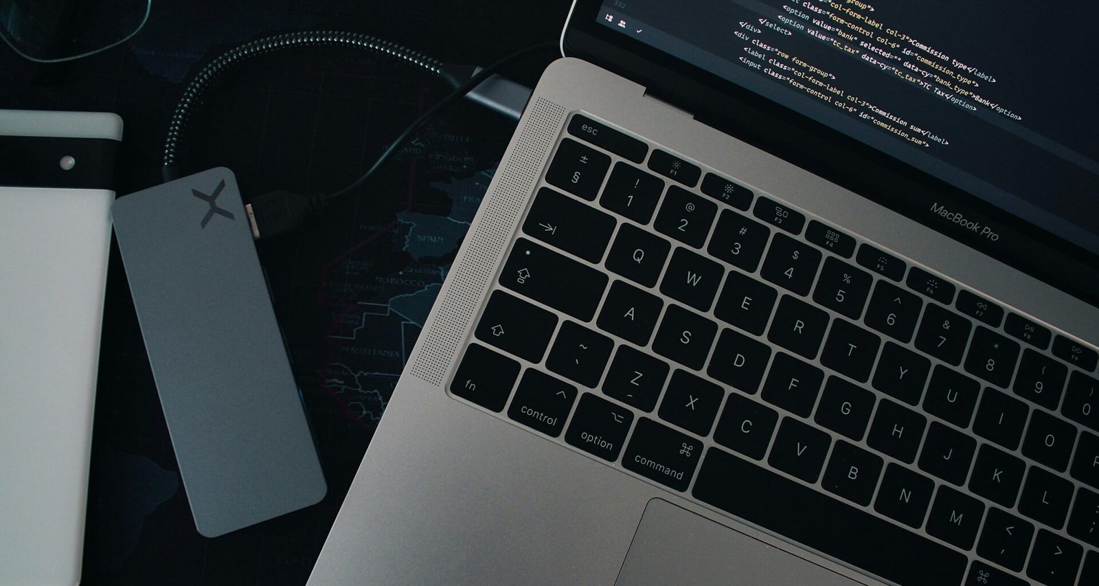 Ein moderner Laptop steht auf einem hellen Schreibtisch mit Hintergrundlicht und Zubehör, ideal für Arbeit im Homeoffice oder Büro.