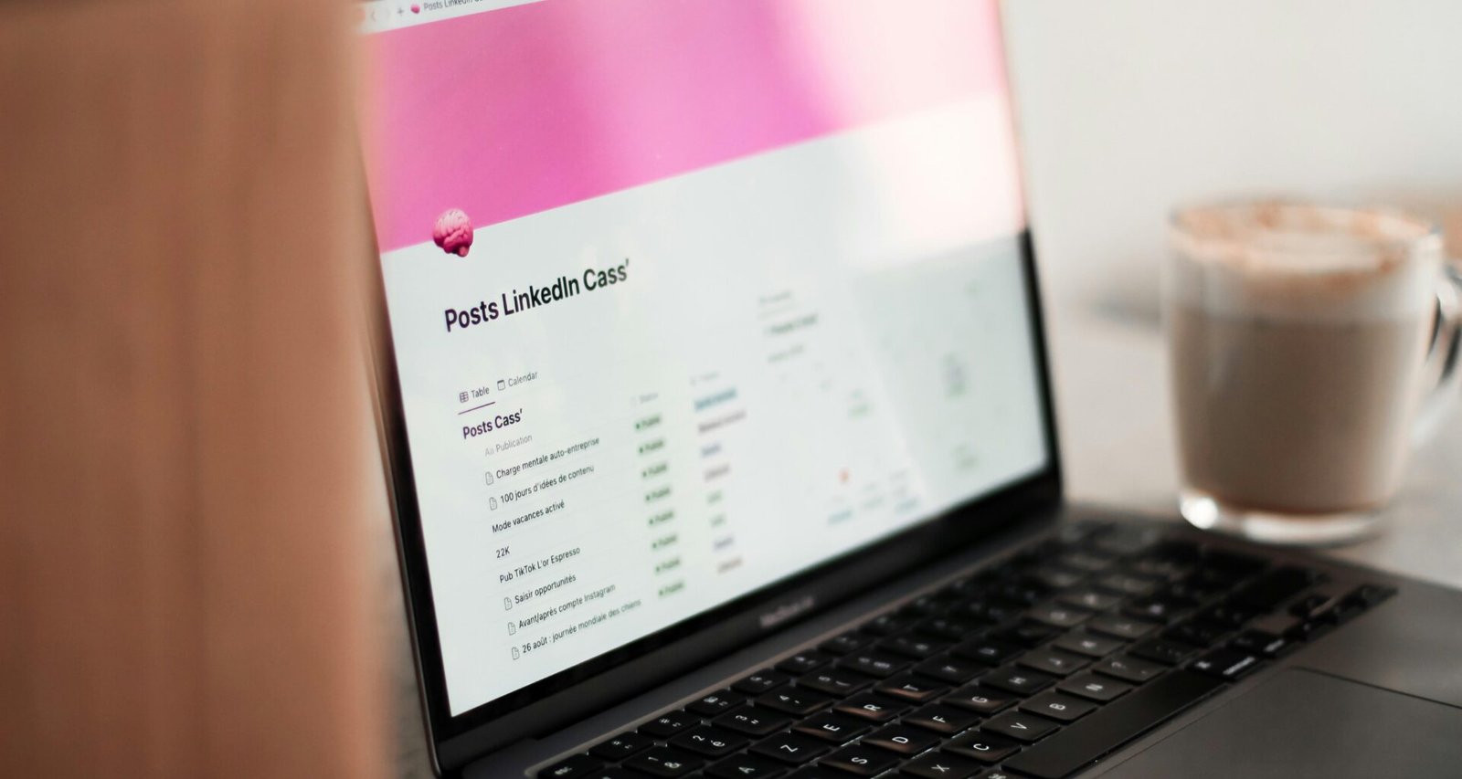 Ein Laptop steht auf einem Holztisch, daneben eine Tasse Kaffee – Symbol für Arbeit und Technologie im Büroalltag.