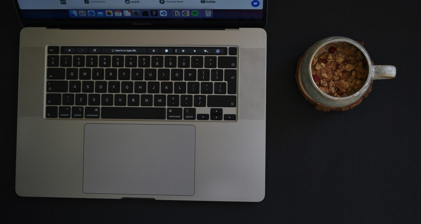 Ein Laptop steht auf einem Tisch, daneben eine Schale mit Essen – modernes Arbeiten und Pausen im Alltag am Arbeitsplatz.