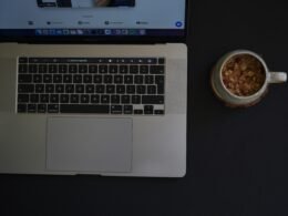 Ein Laptop steht auf einem Tisch, daneben eine Schale mit Essen – modernes Arbeiten und Pausen im Alltag am Arbeitsplatz.